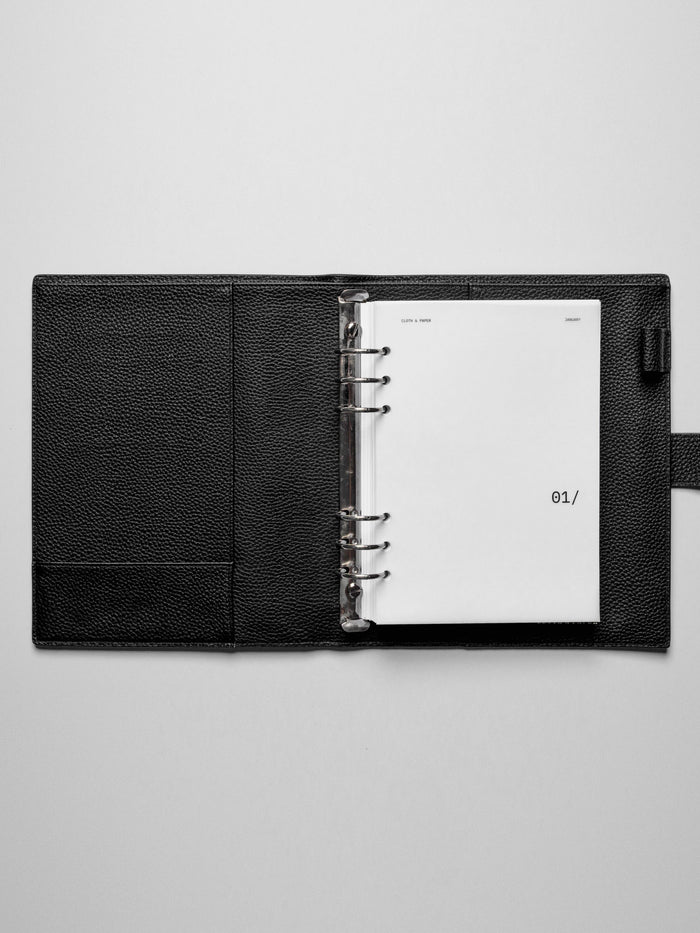 Image shows the January dashboard used in a black leather A5 ring-bound planner.