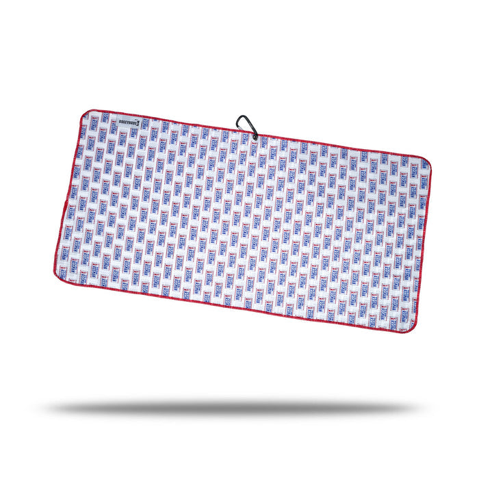 The ASSMAN - Towel is a rectangular microfiber towel with blue and red geometric patterns on white, finished with red trim. It features a black clip, an eyelet hanging loop, and a small label, shown on a white background with shadow.
