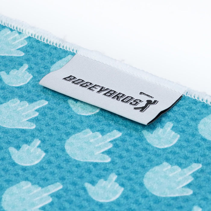 Introducing the Birdie Finger - Towel: a blue microfiber towel with repeating white hand shapes flipping the bird. It features double-sided print, clip and eyelet for easy hanging, and a BOGEYBROS golfer silhouette label near the top.