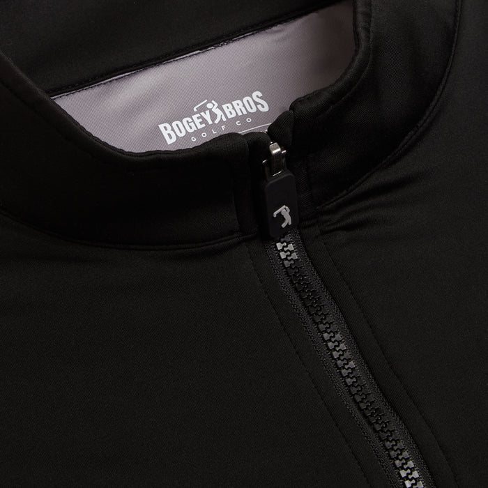 Close-up of the Black - Q-Zip jacket with a visible zipper and pull tab. Inside the collar, a “BOGEY BROS GOLF CO” label appears in white. Smooth, stretchy fabric ensures an athletic fit and moisture-wicking performance.