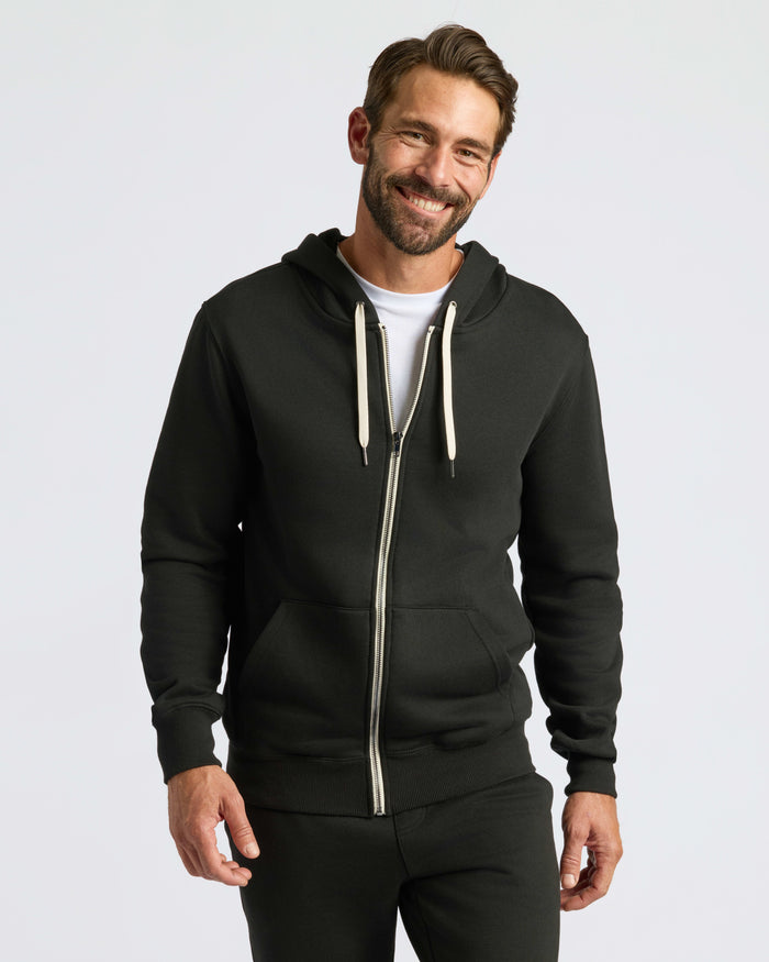 Black Fleece French Terry Zip Hoodie worn by smiling man.