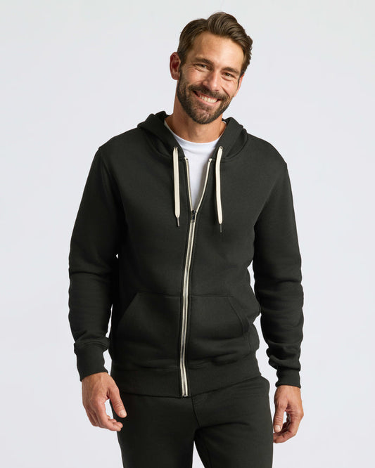 Black Fleece French Terry Zip Hoodie worn by smiling man.