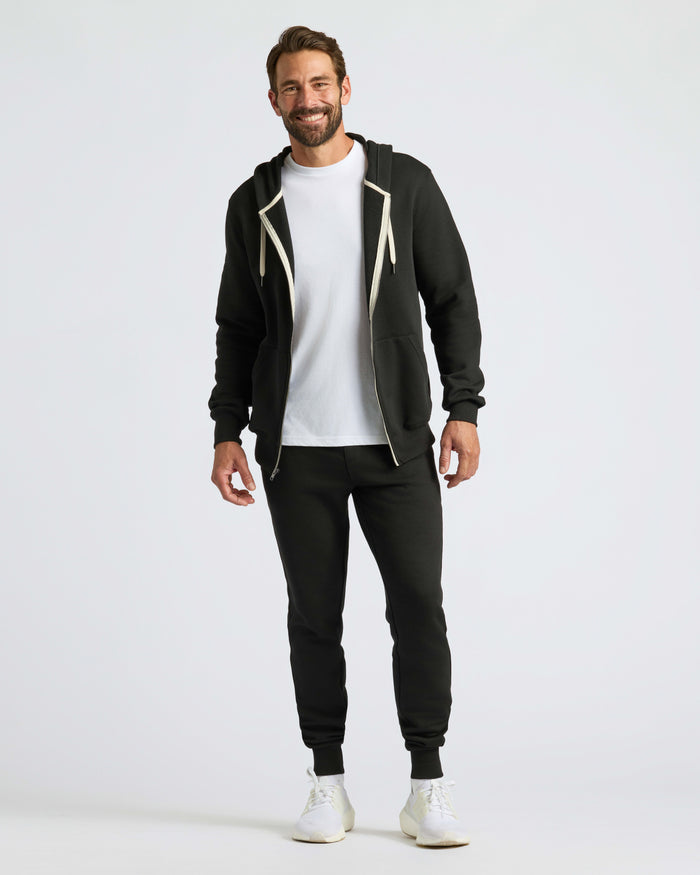 Man wearing Black Fleece French Terry Zip Hoodie, joggers, and sneakers.