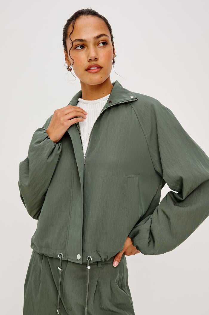 Black Jacket With Oversized Relaxed Fit High Funnel Neck Dropped Shoulders Long Sleeves Center-Front Ties Side-Seam Zipper in Ivy Colorway - Upper Body Front View Featured on Model