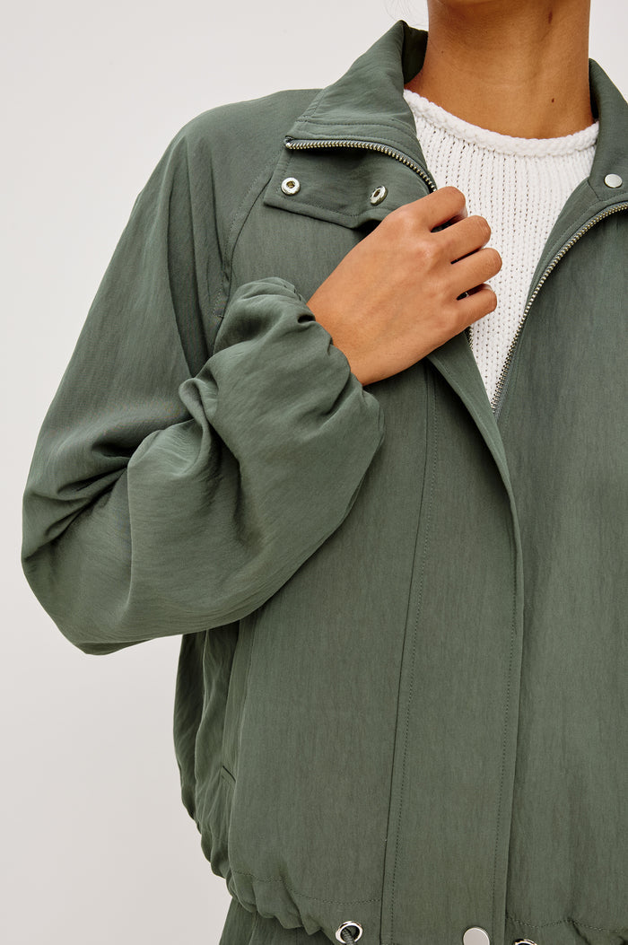 Black Jacket With Oversized Relaxed Fit High Funnel Neck Dropped Shoulders Long Sleeves Center-Front Ties Side-Seam Zipper in Ivy Colorway - Upper Body Front Close Up View Featured on Model