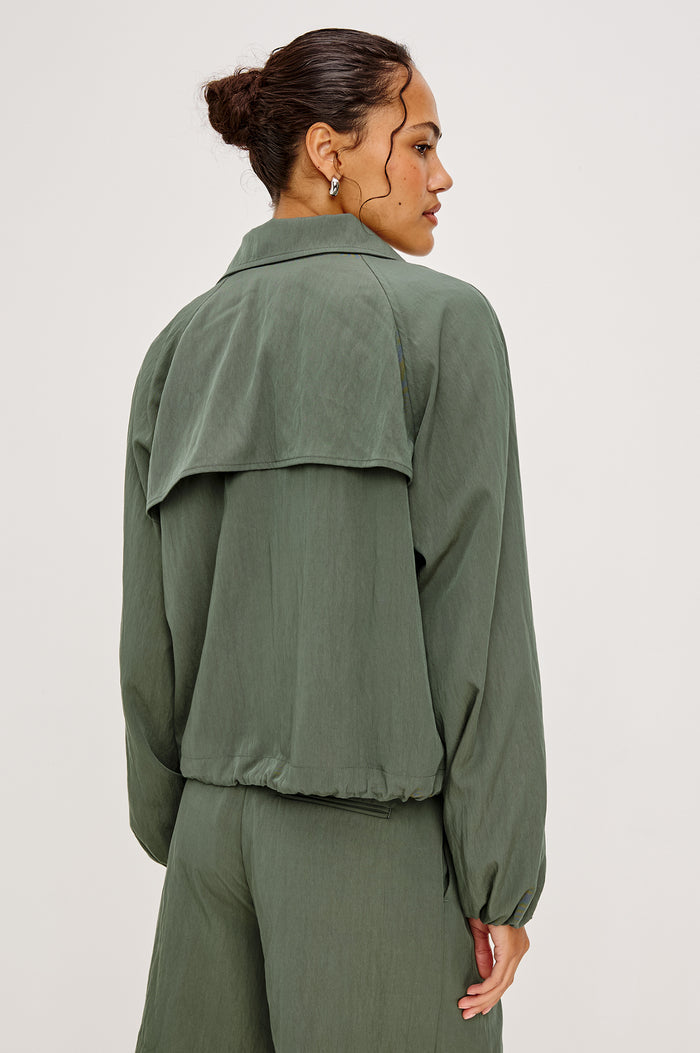 Black Jacket With Oversized Relaxed Fit High Funnel Neck Dropped Shoulders Long Sleeves Center-Front Ties Side-Seam Zipper in Ivy Colorway - Full Body Front View Featured on Model
