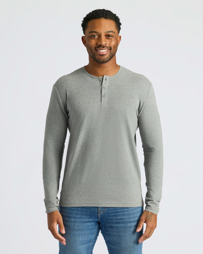 Man wearing Heather Gray Classic Long Sleeve Henley and blue jeans.