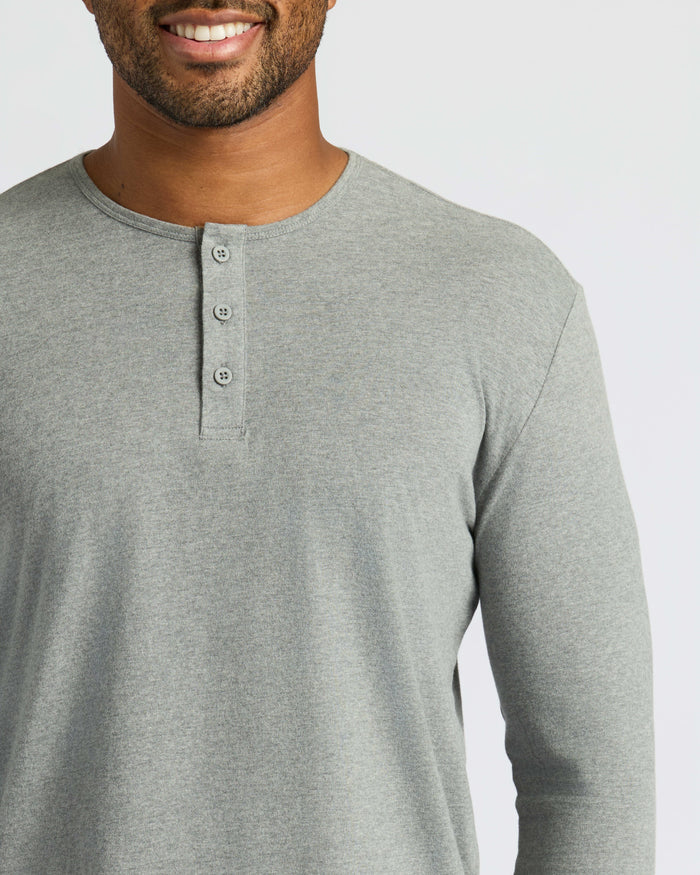Man wearing Heather Gray Classic Long Sleeve Henley, smiling slightly.