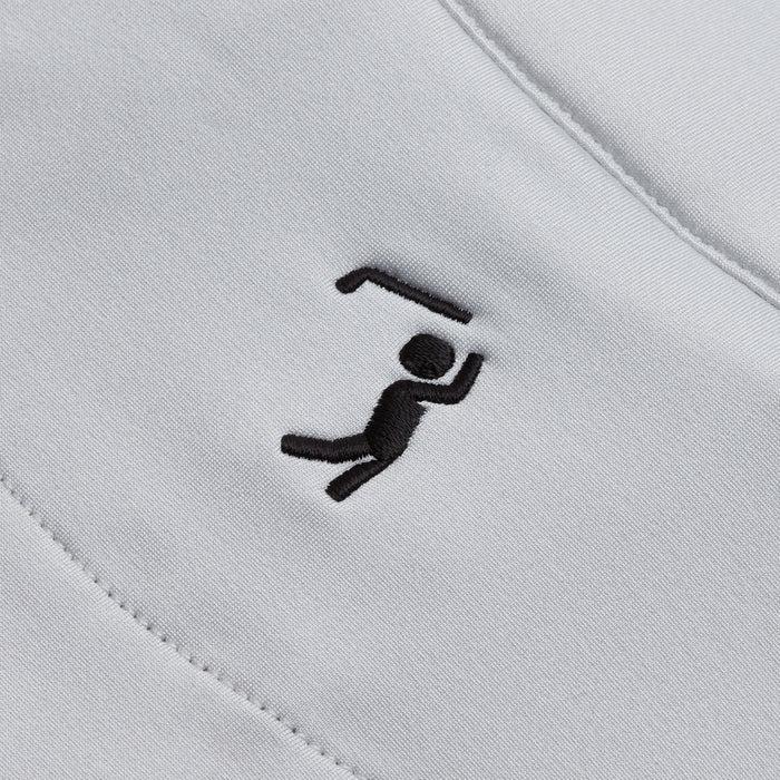 A close-up of the Bone - Q-Zip’s white, athletic-fit fabric showcases a small black embroidered stick figure lifting a bent bar. Diagonal stitching at the edges highlights both its durability and stylish design.
