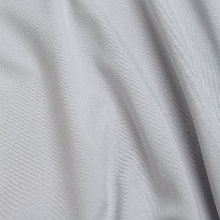 A close-up of Bone - Q-Zip’s light gray fabric shows a smooth, fine weave with gentle folds and a subtle sheen. The athletic fit material features built-in moisture wicking, ensuring all-day comfort.
