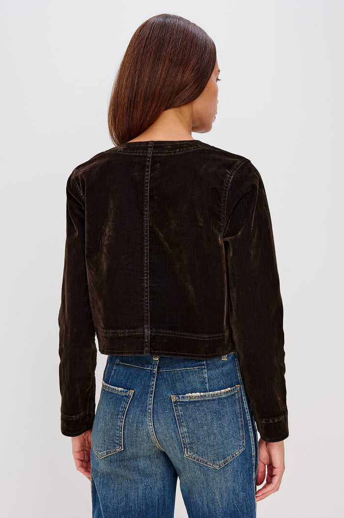 Capistrano Cropped Jacket in Chocolate Velvet Flocked Denim With Crew Neckline, Indigo Wash, Front Buttons, Buttoned Chest Pockets, and Long Sleeves in Chocolate Flocking Colorway - Upper Body Back View Featured on Model