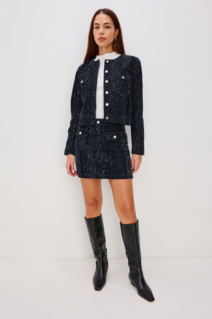 Capistrano Cropped Jacket in Denim Tweed Texture With Crew Neckline, Front Buttons, Buttoned Chest Pockets, and Long Sleeves in Denim Tweed Colorway - Full Body Front View Featured on Model
