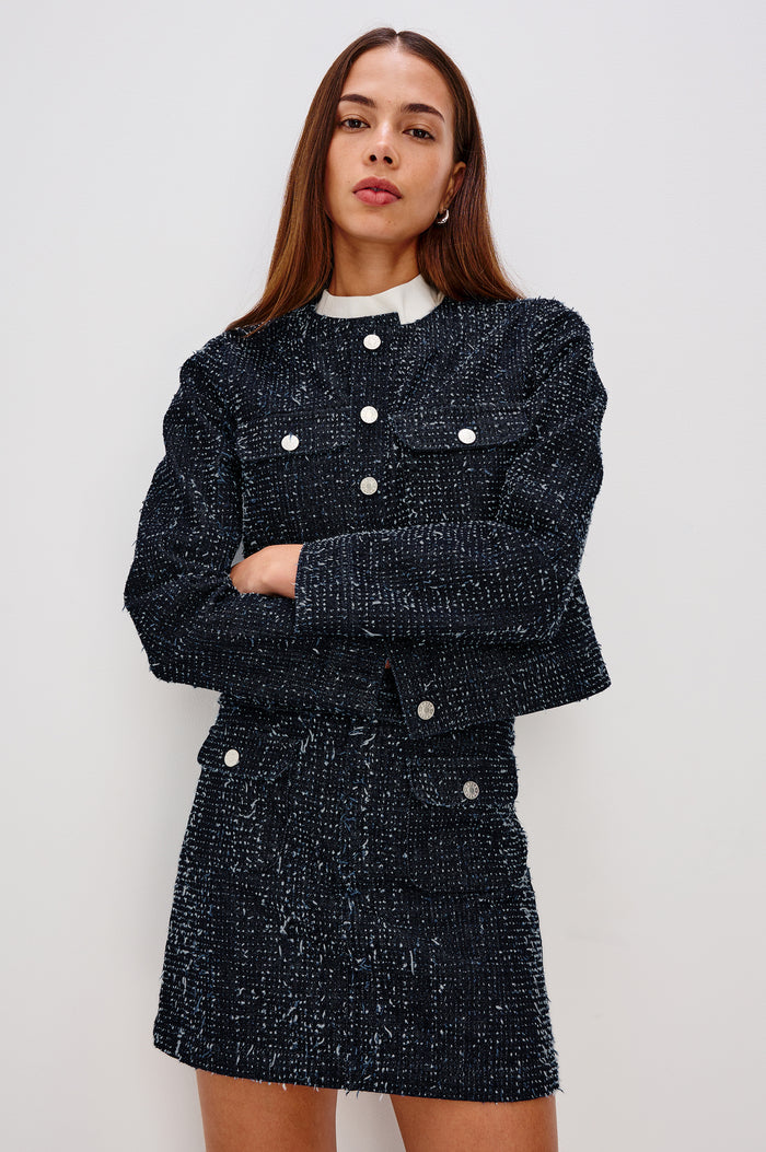 Capistrano Cropped Jacket in Denim Tweed Texture With Crew Neckline, Front Buttons, Buttoned Chest Pockets, and Long Sleeves in Denim Tweed Colorway - Upper Body Front View Featured on Model