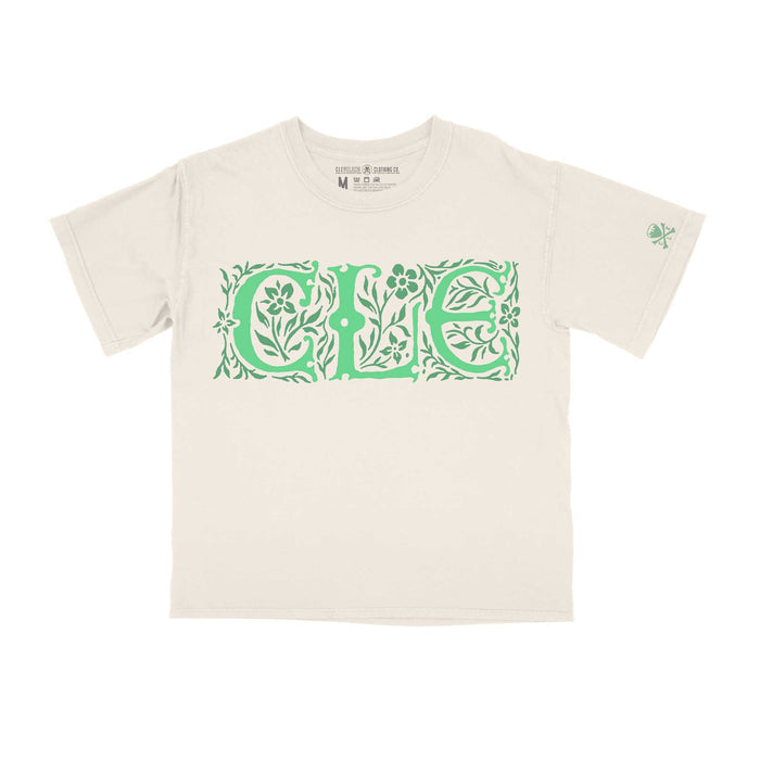 A white crew neck t-shirt with a cropped fit and the text 'CLE' designed in a Celtic pattern in green.