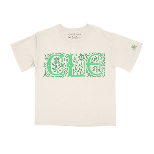 A white crew neck t-shirt with a cropped fit and the text 'CLE' designed in a Celtic pattern in green.