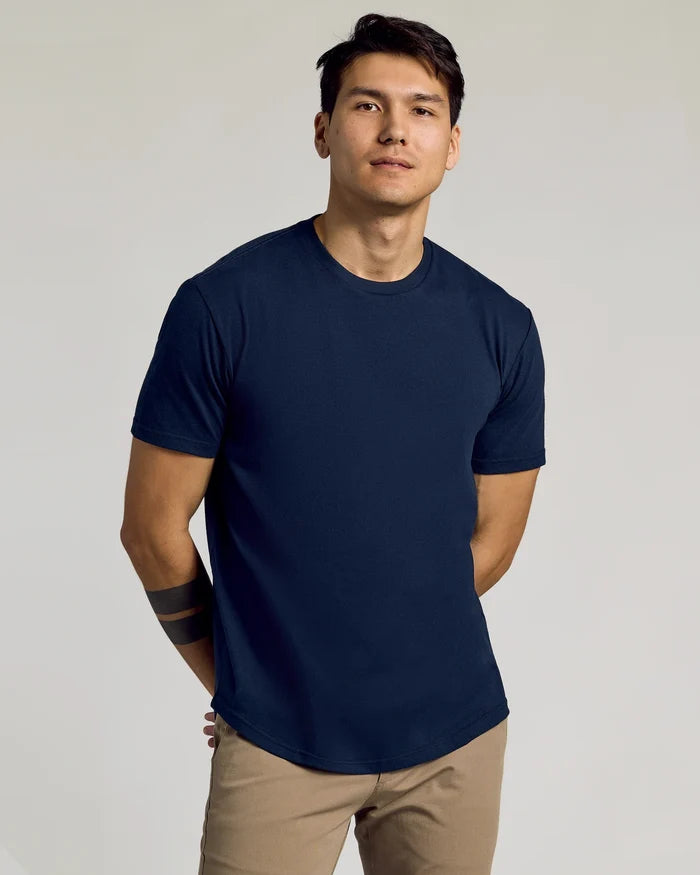 Man wearing a navy blue Classic Curved Hem Crew Neck 10-Pack t-shirt paired with beige pants, showcasing a comfortable and stylish men's basic look.