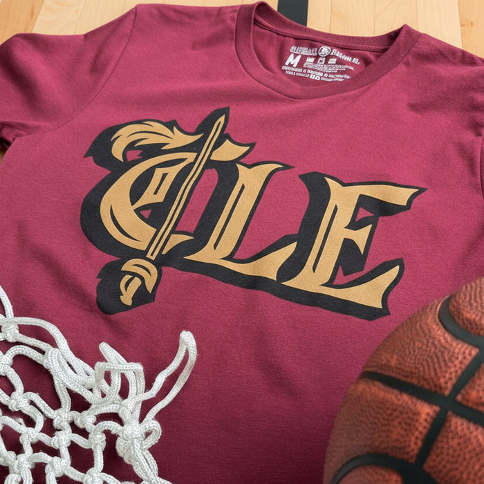 Maroon t-shirt with 'CLE' design, basketball, and net on a wooden surface