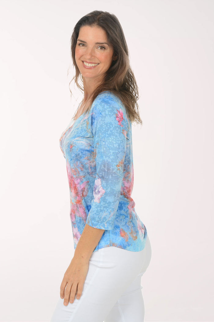 Woman wearing a multicolored 3/4 sleeve top.