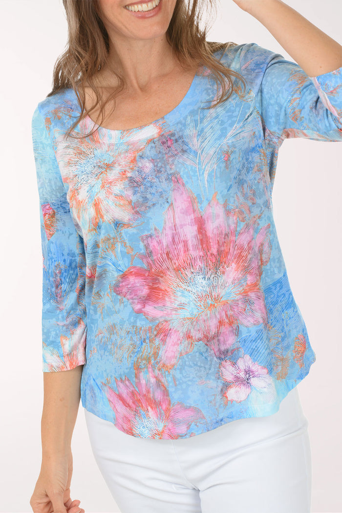 Woman wearing a multicolored 3/4 sleeve top.