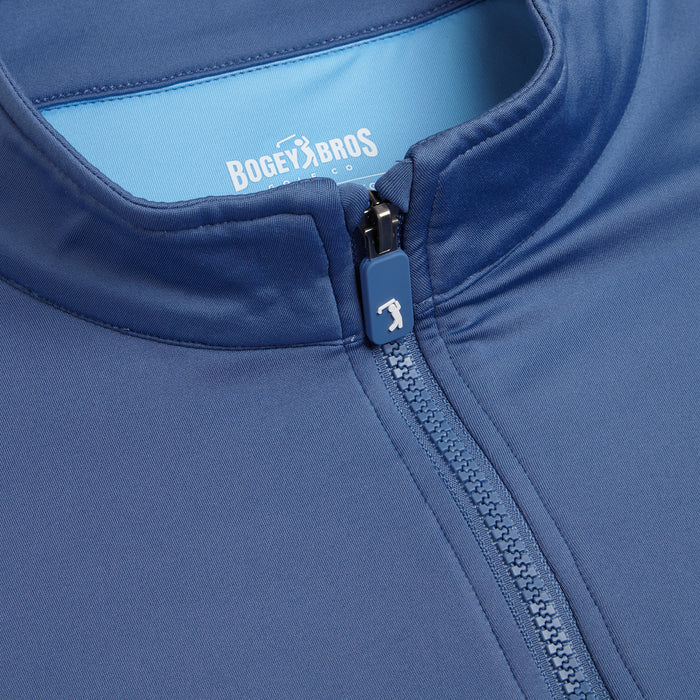 Close-up of the Cooler Blue - Q-Zip athletic jacket with a zipper, featuring an athletic fit. The zipper pull has a white golf club icon, and “Bogey Bros Co.” is printed in white inside the collar on light blue lining.