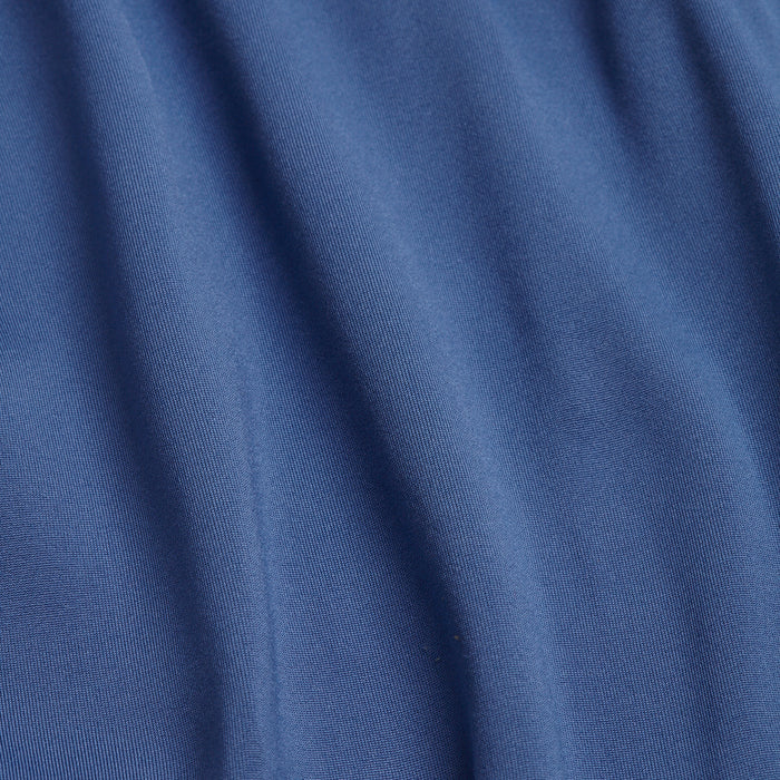 Close-up of Cooler Blue - Q-Zip fabric: soft blue material with smooth, vertical folds. Subtle texture and gentle ripples highlight its flexibility—perfect for athletic wear or moisture-wicking performance.