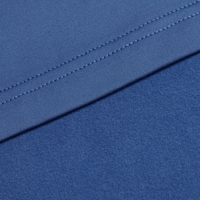 Close-up of two layers of Cooler Blue - Q-Zip fabric; the upper layer features neat edge stitching, while the lower layer is smooth and soft with moisture-wicking properties. Both fabrics overlap diagonally, suggesting contrasting textures.