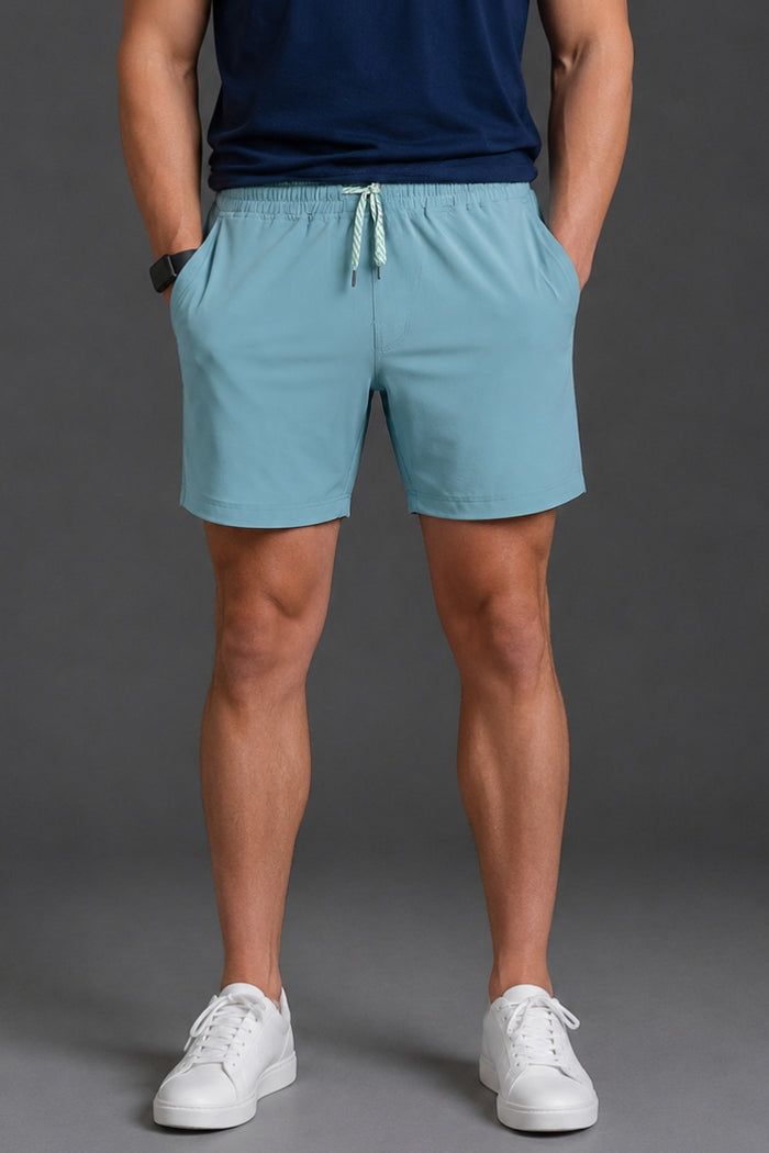 Person wearing light blue shorts and white sneakers on a gray background || Underseas