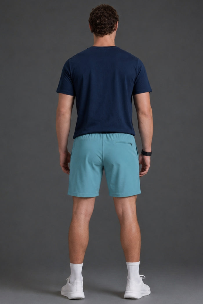 Man wearing a navy t-shirt and teal shorts on a gray background || Underseas