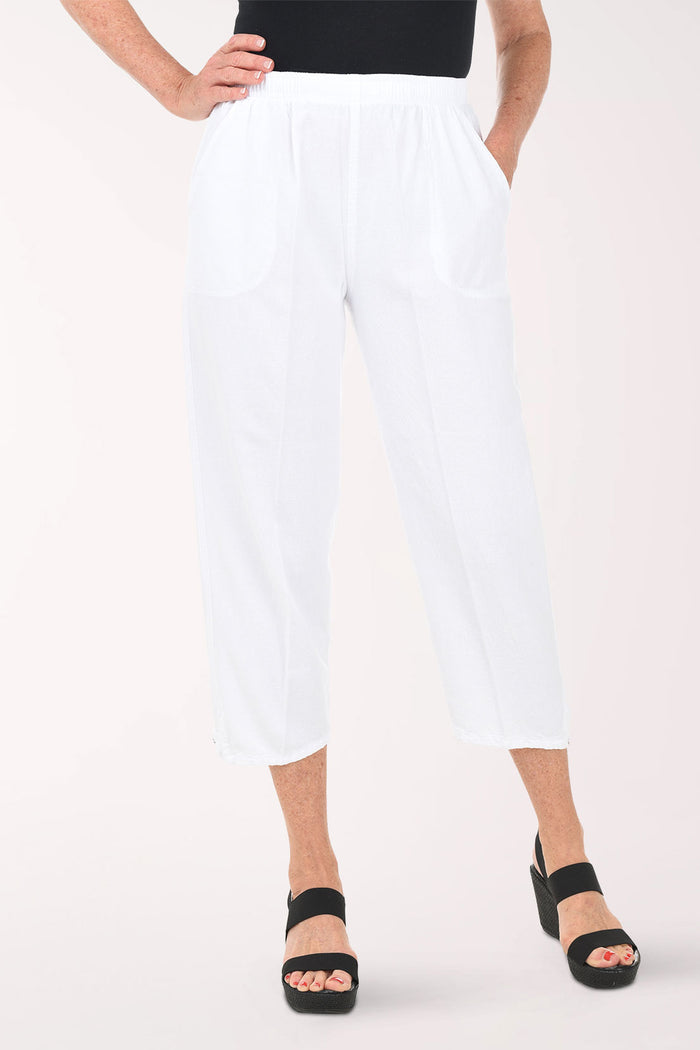 Person wearing white pants and black shoes on a white background