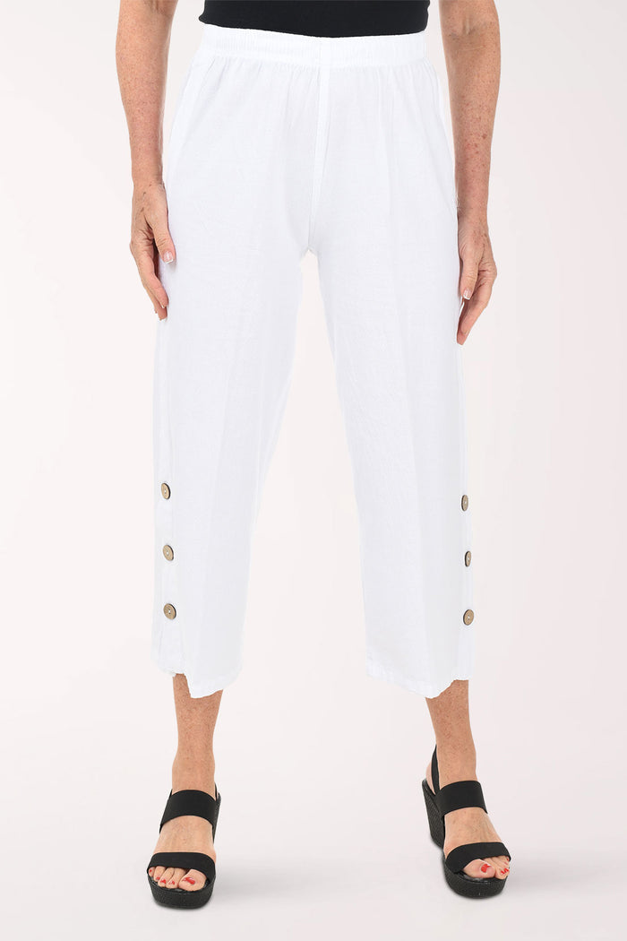 White pants with gold buttons worn by a person on a white background