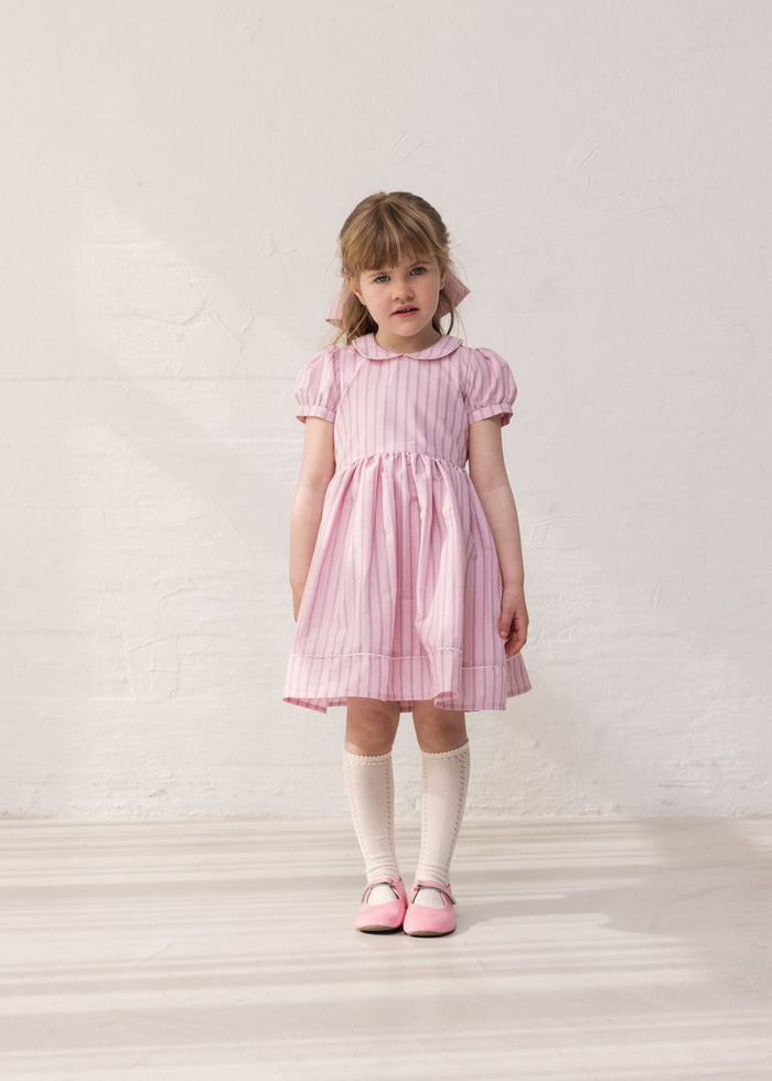 Girl in a light red dress with stripes