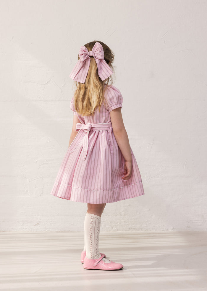 Girl in a light red dress with stripes