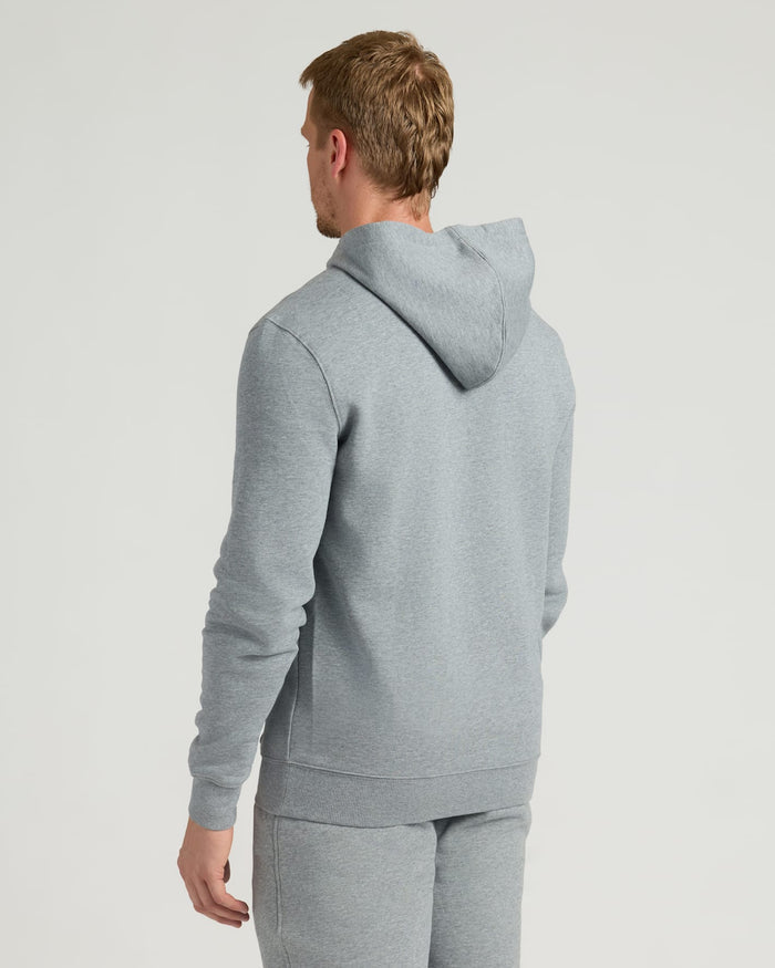Man wearing a Dark Heather Gray Fleece French Terry Pullover Hoodie viewed from the back, showcasing a comfortable fit and hood detail in a casual setting.