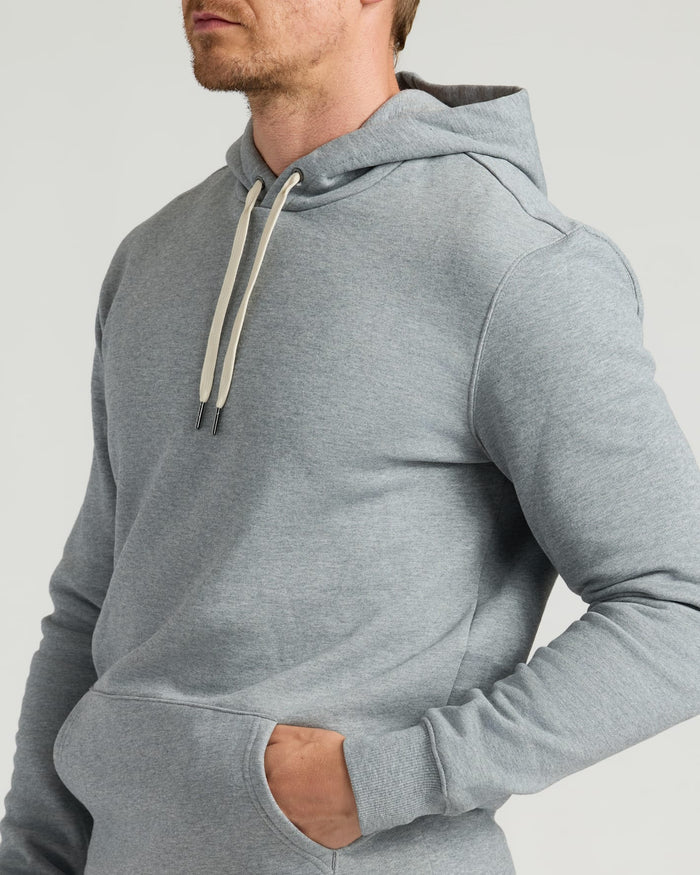 Close-up of a man wearing a Dark Heather Gray Fleece French Terry Pullover Hoodie with a kangaroo pocket and adjustable drawstrings.