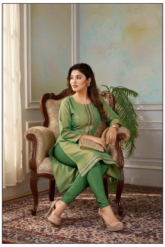 Kurti Connection USA green tissue silk kurti with intricate embroidery, worn by a model sitting in a vintage chair.