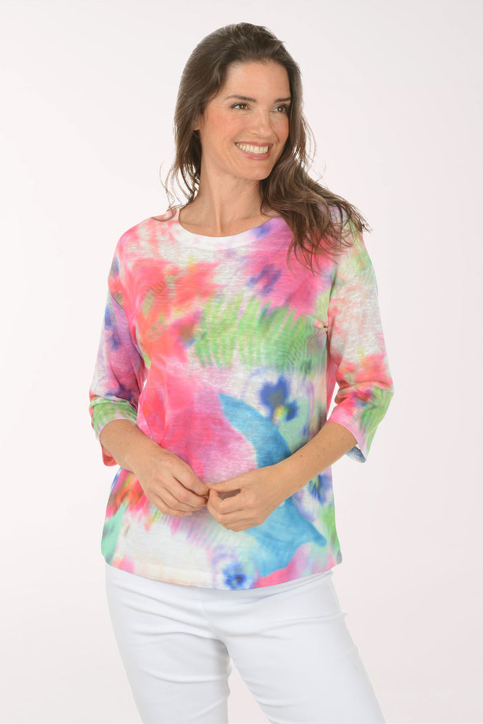 A woman wearing a multicolored tie-dye top.