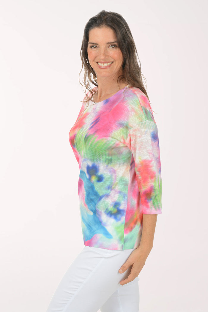 A woman wearing a multicolored tie-dye top.