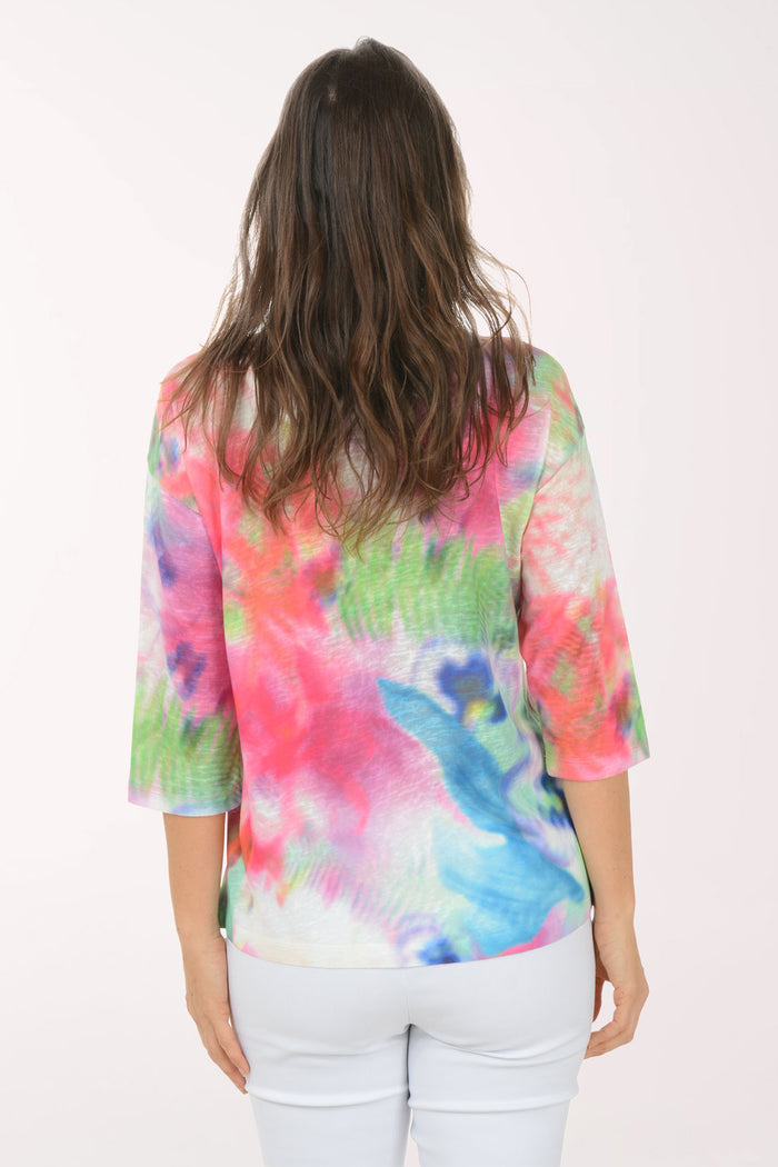 A woman wearing a multicolored tie-dye top.