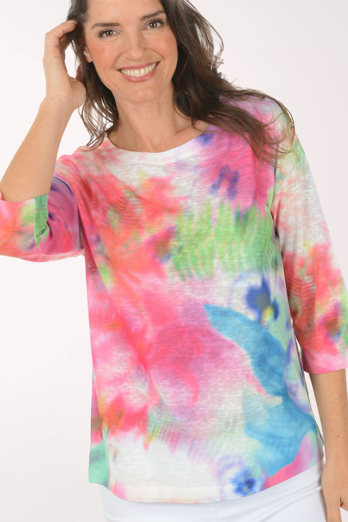 A woman wearing a multicolored tie-dye top.