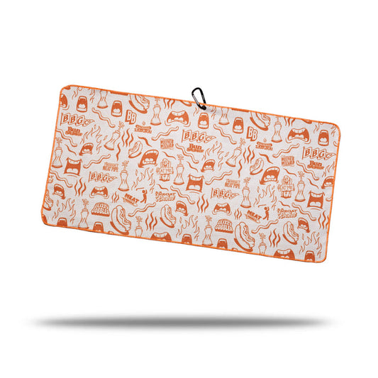 The Glizzy Gobbler - Towel is a rectangular, orange and white microfiber towel with BBQ-themed doodles, “BBQ” text, double-sided print, and a clip with eyelet for hanging. It appears to float above a shadow on a white background.