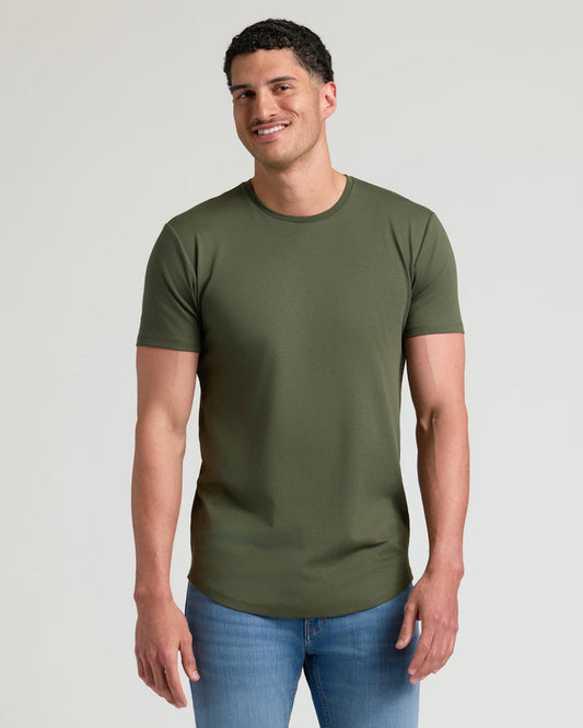 A smiling man wearing an olive green crew neck t-shirt with a curved hem paired with blue jeans, showcasing the Tall Pima Cotton Blend Curved Hem Crew 4-Pack men's basics.
