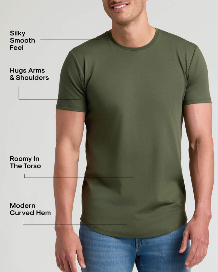 Man wearing an olive green Tall Pima Cotton Blend Curved Hem Crew 4-Pack t-shirt with a modern curved hem, fitted sleeves hugging arms and shoulders, and a roomy torso for comfortable men's basics.