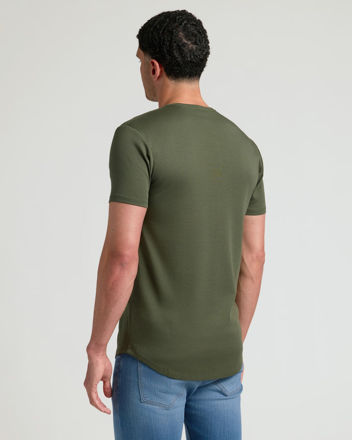 Man wearing an olive green Tall Pima Cotton Blend Curved Hem Crew 4-Pack t-shirt paired with blue jeans, shown from the back against a plain background