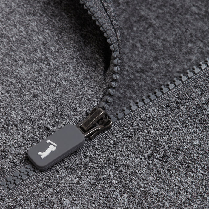 Close-up of the Heather Gray - Q-Zip, featuring an athletic fit with a partially unzipped gray zipper on dark heathered fabric. The gray pull displays a white animal icon, and both the zipper teeth and fabric texture are clearly visible.