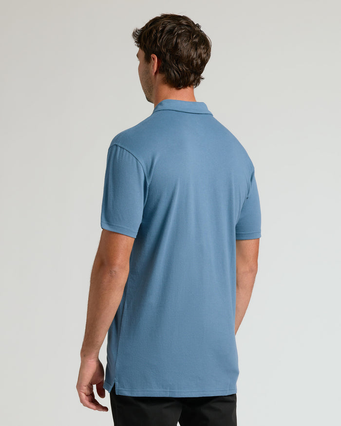 Man in light-blue Wardrobe Classic Tall Polo, back view.
