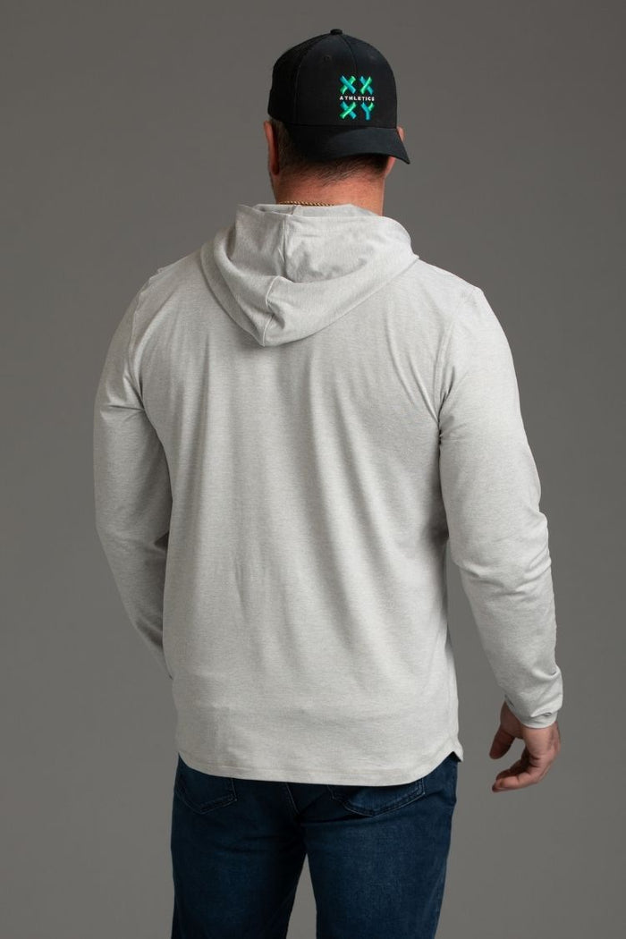 Person wearing a gray hoodie and dark cap with a logo on a gray background || light heather gray - 1