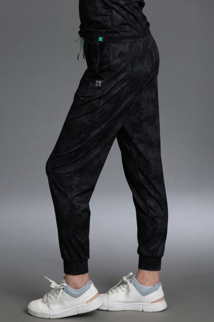 Black jogger pants worn by a person on a gray background || Black Camo