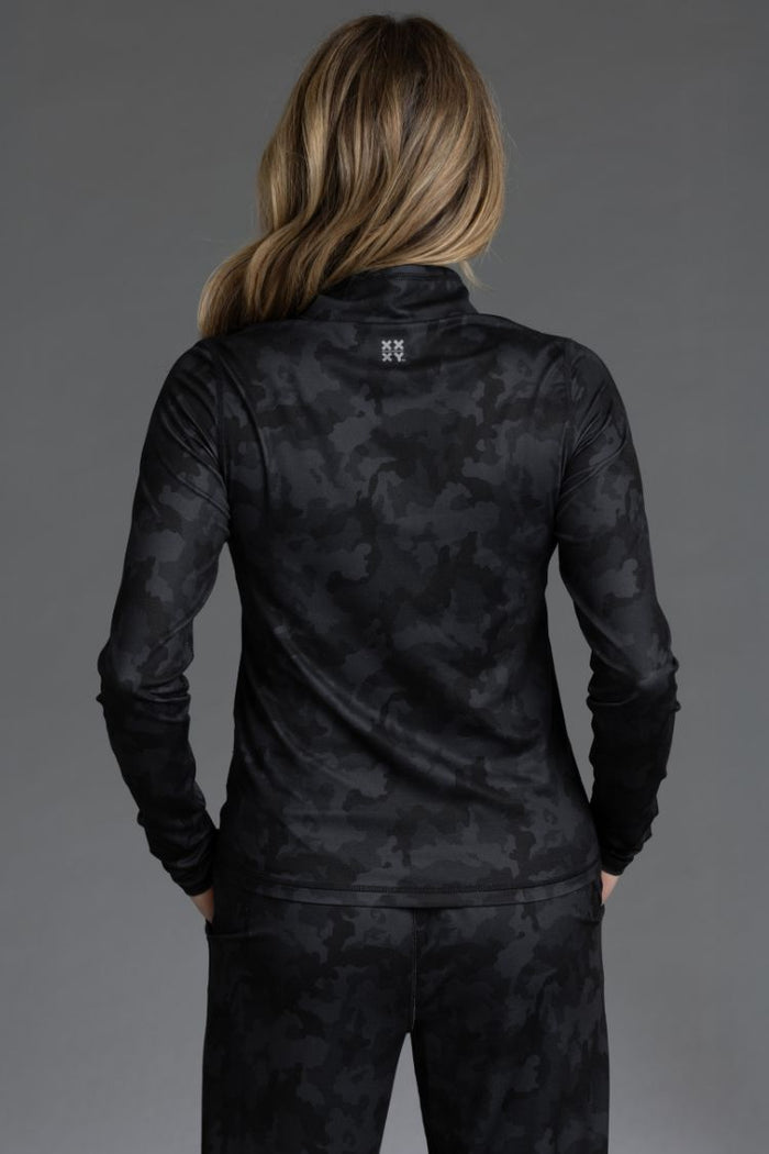 Person wearing a black camouflage long-sleeve top and pants against a gray background || Black Camo