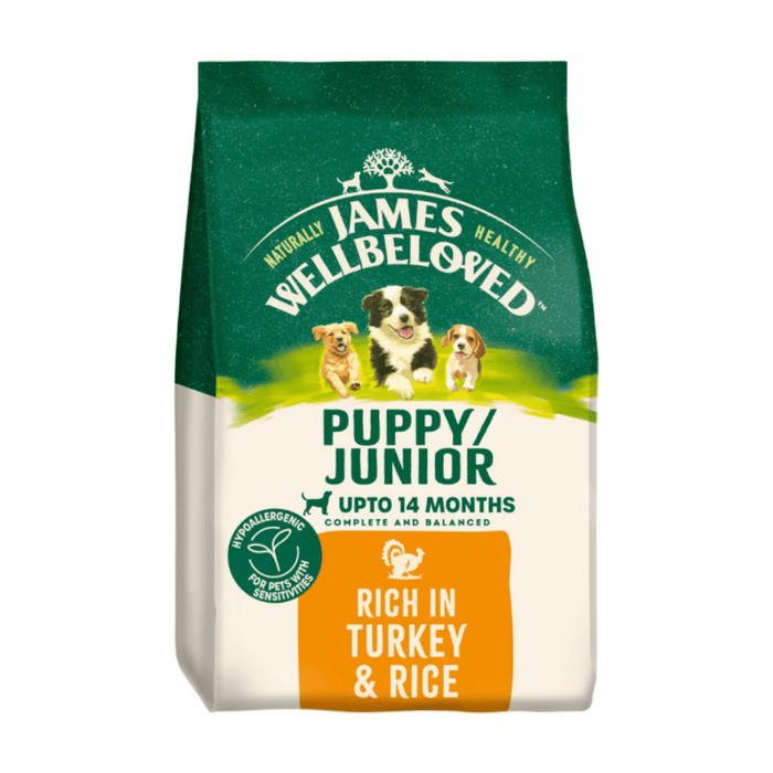 White background with a bag of James Wellbeloved Turkey & Rice Puppy/Junior Food. Packaging is green and cream with 3 puppies pictured, with text 'Puppy/Junior ,Upto 14 months, Rich in Turkey & Rice'.