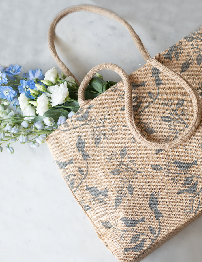 Beige jute tote bag with a bird print.